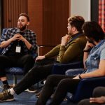 Participantes jovens interagem durante um painel de discussão em um evento.