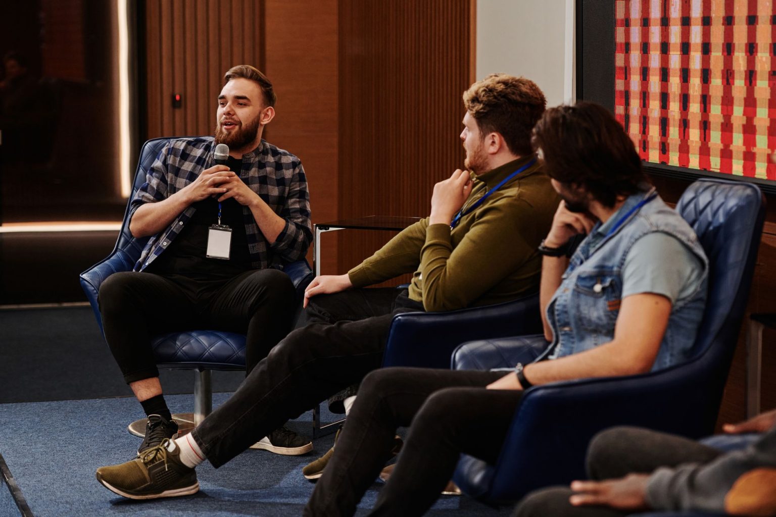 Participantes jovens interagem durante um painel de discussão em um evento.