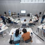 Estudantes participam de uma atividade prática em sala equipada com recursos tecnológicos.