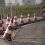Cones de trânsito alinhados sinalizam uma área de obras em uma via.