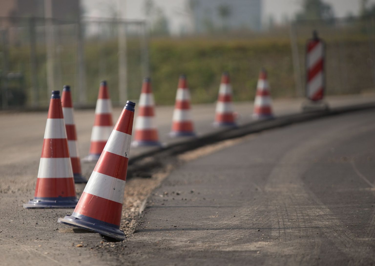 Cones de trânsito alinhados sinalizam uma área de obras em uma via.