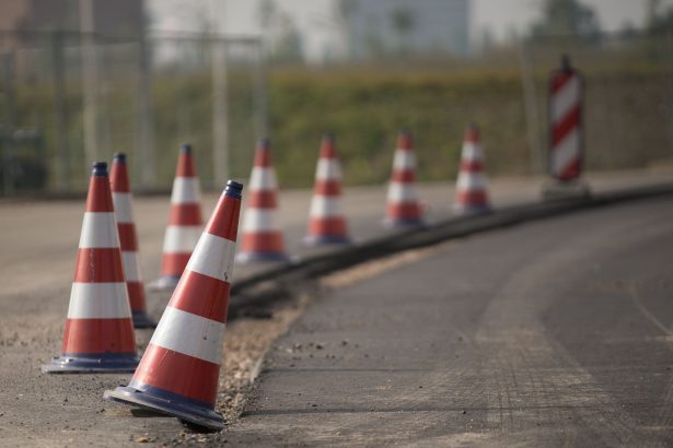 Cones de trânsito alinhados sinalizam uma área de obras em uma via.