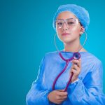Profissional de saúde conversa com uma mulher durante atendimento clínico.
